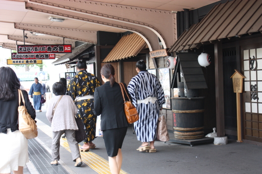 Sumo wrestlers are walking at the station.